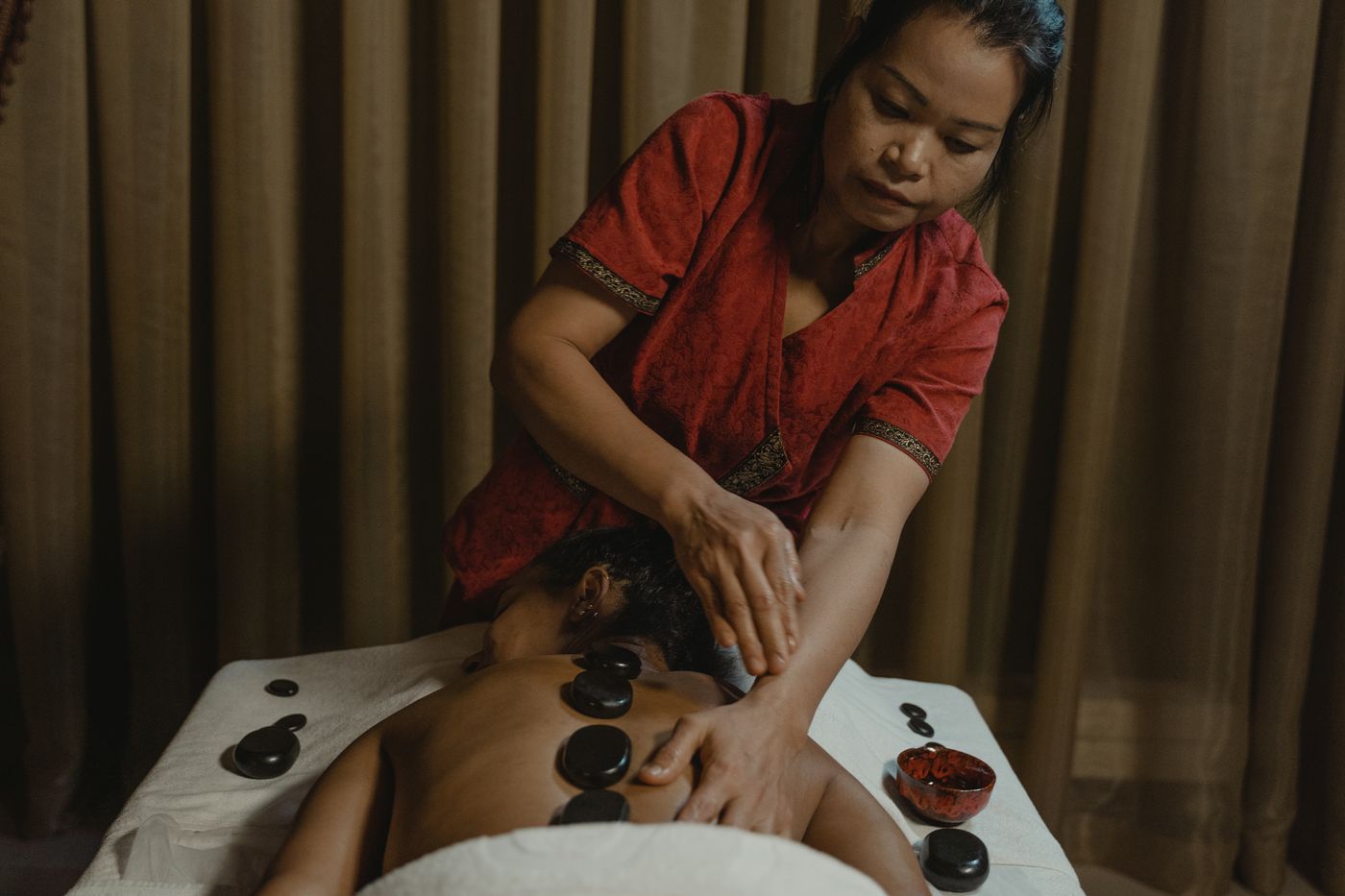 Hot stones arranged along the spine by a therapist